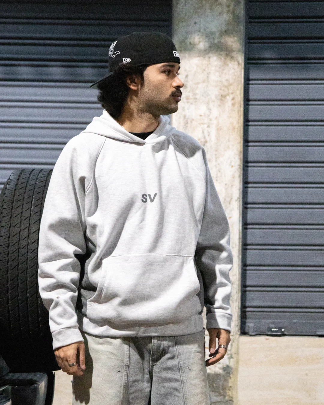 Modelo con hoodie Star Vision gris claro en una calle de noche